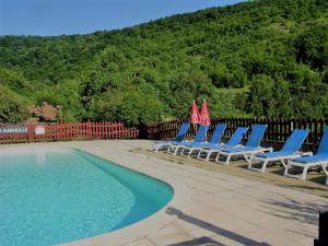 a group of lounge chairs next to a swimming pool at la Frégière Chalets in Clairvaux-dʼAveyron
