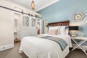 a bedroom with a bed, a dresser and a lamp at Captains Retreat Apartments and Cottages in Williamstown