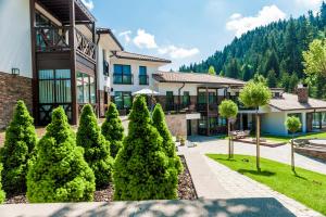 a house with trees in front of a building at Villa Helia in Dolný Kubín