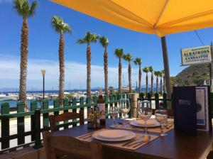 a table with wine glasses on a balcony with palm trees at Albatross Studios in Kefalos