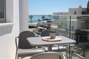 einen Tisch und Stühle auf einem Balkon mit Meerblick in der Unterkunft Phaedrus Living: Seaside Luxury Flat Lighthouse 67 in Paphos City