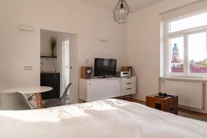 a bedroom with a bed and a tv and a table at Modern studio in the heart of the city in Maribor