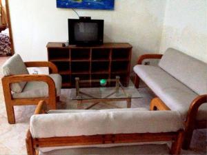 a living room with two couches and a tv at Pacot Breeze Hotel in Port-au-Prince
