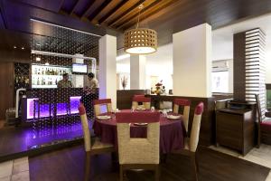 a dining room with a table and chairs and a bar at Accord Hotel in Mumbai