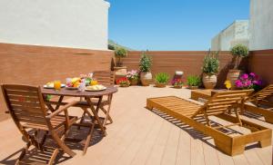 a patio with a table and chairs and flowers at Elma Suites in Rethymno