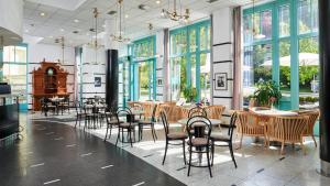 un restaurant avec des tables, des chaises et des fenêtres dans l'établissement OREA Spa Hotel Cristal, à Mariánské Lázně