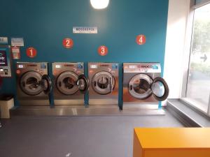 Hay cuatro lavadoras en una lavandería. en Apartment Sinkó - FREE PARKING central 2 bedrooms 4 single beds, en Budapest
