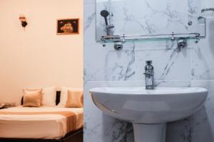 Un baño con lavabo y un dormitorio con cama. en Hotel Digana, en Digana