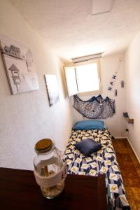 una piccola camera con letto e un barattolo sul tavolo di Villetta sul mare in residence a Brucoli