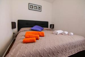 un letto con cuscini arancioni e bianchi di Villetta sul mare in residence a Brucoli