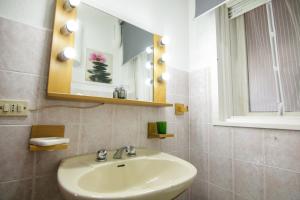 uma casa de banho com um lavatório e um espelho em Villetta sul mare in residence em Brucoli