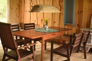 a wooden table with chairs and a vase of flowers on it at Dzikie Roztocze - Stara Chata in Krasnobród +13 photos