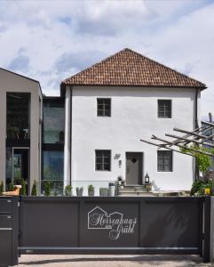 Herrenhaus am Grübl في لانا: بيت ابيض امامه سياج اسود