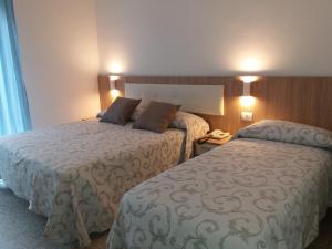 a hotel room with two beds next to each other at Hotel Niagara in Marotta
