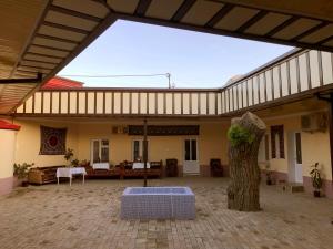 un edificio con un árbol en medio de un patio en Guest House Firuza, en Samarkand