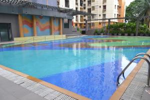 a large swimming pool with blue water in a building at Princeton Club in Kolkata