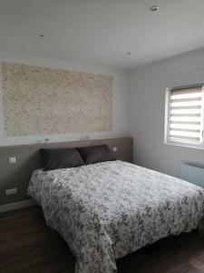 a bedroom with a bed with a floral bedspread at Hossegor Les Bécasses in Soorts-Hossegor