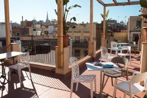 Un patio con mesas y sillas en un tejado. en Àmfores Boutique Guest House, en Barcelona