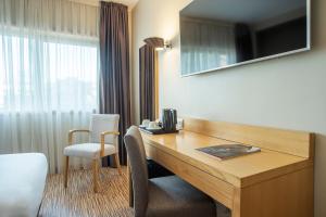 a hotel room with a desk and a window at HF Tuela Porto in Porto