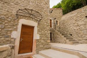 a stone building with a wooden door and stairs at Loft Stories in Baix