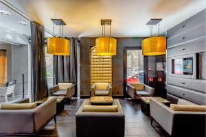 a waiting room with couches and chairs and lights at L'Adresse in Paris