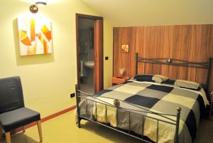 Bed & Breakfast "A Casa di Anto" في Mentana: غرفة نوم بسرير وكرسي