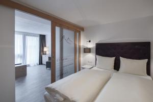 ein Schlafzimmer mit einem großen Bett und einem großen Fenster in der Unterkunft Hotel Bergwelt in Längenfeld