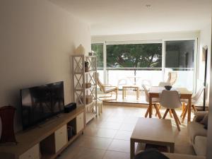 uma sala de estar com uma televisão e uma mesa e cadeiras em Kaminias II Apartament per 4 persones a Politur em Platja d'Aro