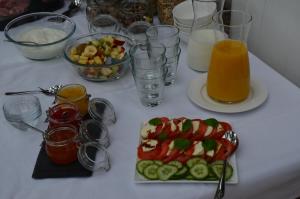 Weingut Erbes-Henn في أورزيغ: طاولة مع طبق من الطعام وكؤوس من عصير البرتقال