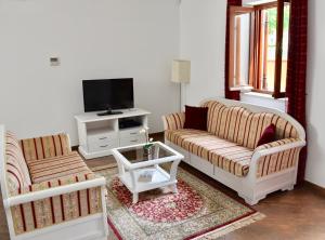 a living room with two couches and a tv at Apartments Villa Riva in Slano