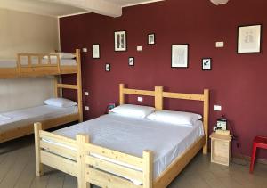 sypialnia z 2 łóżkami piętrowymi i czerwoną ścianą w obiekcie Cascina La Goliarda w mieście Curtatone