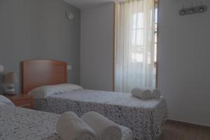 Habitación de hotel con 2 camas y ventana en Apartamentos Rurales Caxila, en Setienes