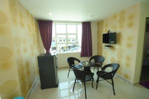 a dining room with a table and chairs and a window at 56 HOTEL in Mentekab