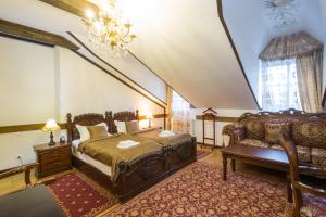a bedroom with a bed and a couch and a chandelier at Zámek Lužec Spa & Wellness Resort in Karlovy Vary