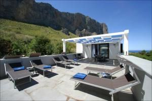 a patio with chairs and a table and a roof at Villa Antonia - Vasca Idromassaggio Terrazza Vista Mare in San Vito lo Capo