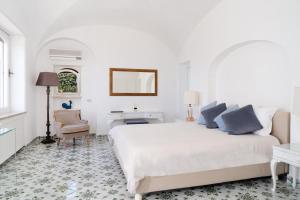Habitación blanca con cama, escritorio y silla en Villa Hibiscus en Capri