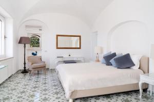 - une chambre blanche avec un lit, un bureau et une chaise dans l'établissement Villa Hibiscus, à Capri
