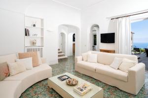 a living room with two white couches and a table at Villa Hibiscus in Capri