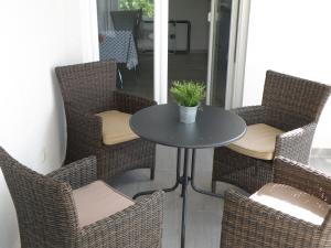 a table with chairs and a potted plant on a porch at Apartments Stella in Krk