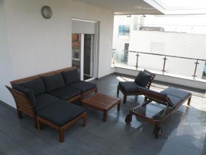 a living room with a couch and two chairs at Apartments Stella in Krk