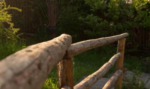 una valla de madera con troncos encima en Pensiunea Colt de Munte en Corbeni