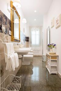 B&B Blanc Maison Etna Relais & Charme في نيكولوسي: حمام مع حوض ودورتين مياه ومرآة