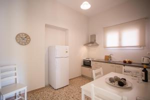 a kitchen with a white refrigerator and a table at Fotini's House in Ýpsos +18 photos