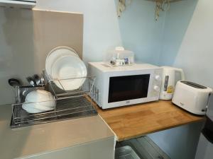 un microondas en la parte superior de una barra de cocina en Samed Your House Family Room, en Ko Samed