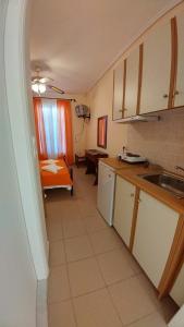 a kitchen with a sink and a table in a room at Araxovoli Studios - Aραξοβόλι Lefkada in Tsoukalades