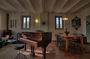 OstraにあるGrande villa storica per vacanze con giardino privato e piscinaのリビングルーム(ピアノ、テーブル付)