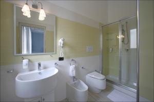 ein Bad mit einem Waschbecken, einer Dusche und einem WC in der Unterkunft Accussì rooms in San Vito lo Capo