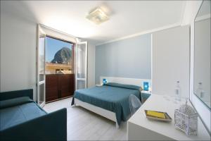 een slaapkamer met een bed, een bank en een raam bij Accussì rooms in San Vito lo Capo