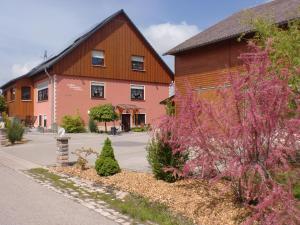 una casa e un edificio con fiori rosa di fronte di Landhaus Dreibirken a Rothenburg ob der Tauber