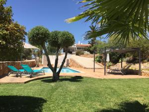 a pool with two chairs and a tree in a yard at Montinho Boutique Studio in Benagil